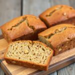 Mini banana bread loafs on a rustic board.